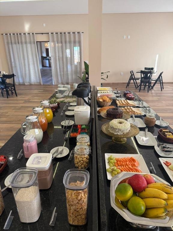 The breakfast table at Pousada Maritaca with fruit, cakes, and breads