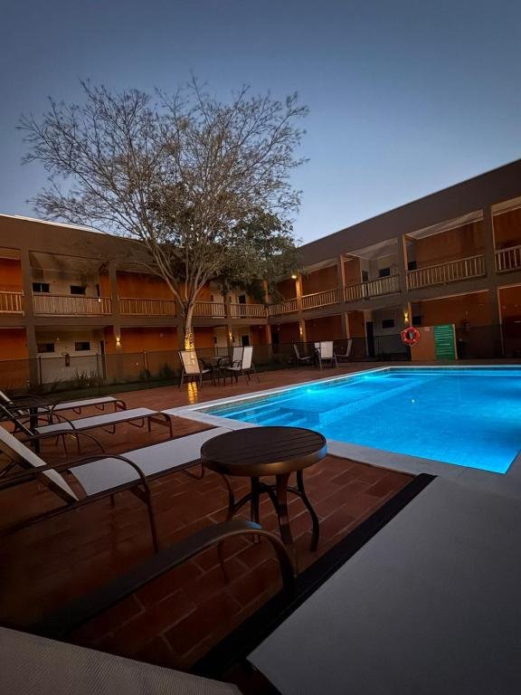 The outdoor pool with hydro jets at Pousada Maritaca, with loungers and tables on the deck